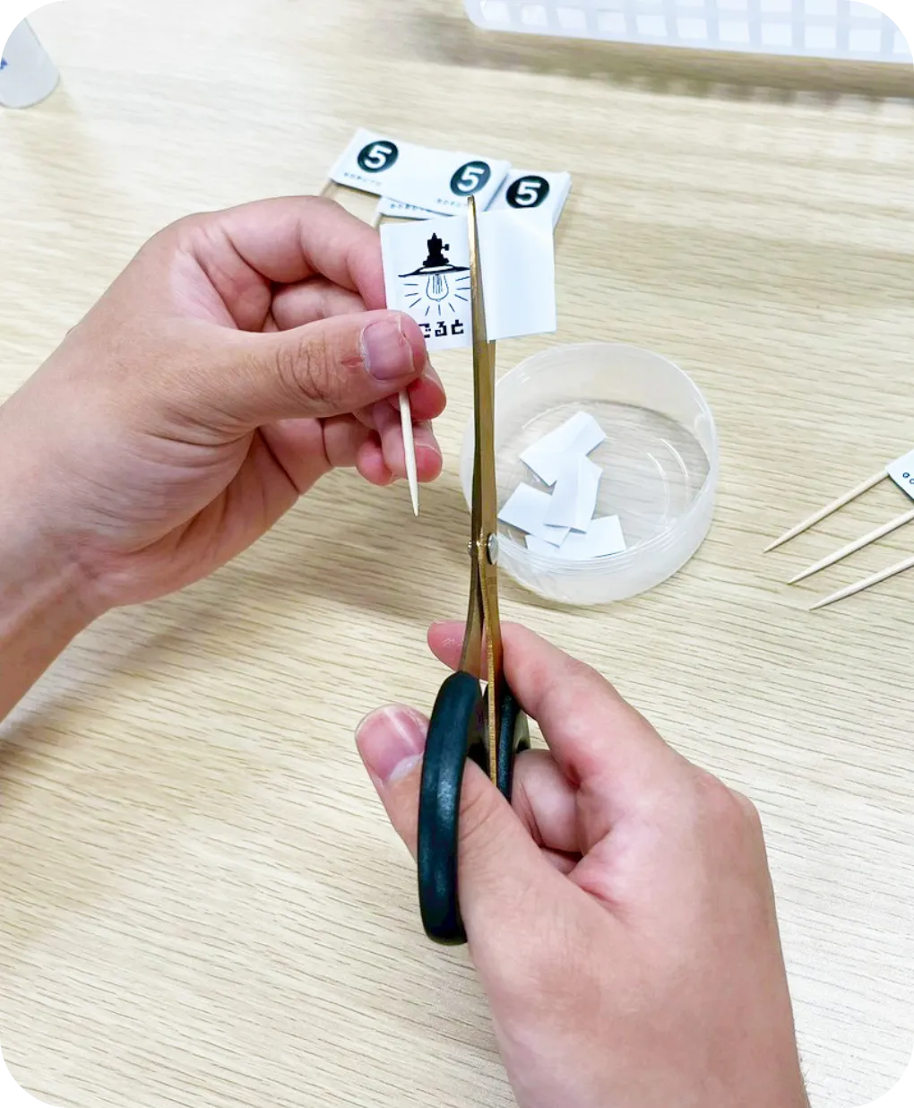小さなアイコンが印刷されたシールを、ハサミを使って形に合わせて切り抜く様子