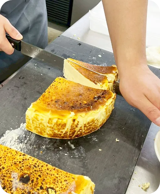 焼き上がったケーキを包丁で丁寧に切り分ける様子